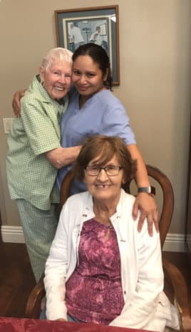 two elderly woman happy with a caregiver