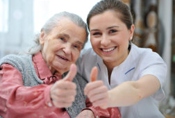 caregiver and an elderly woman posing for the camera