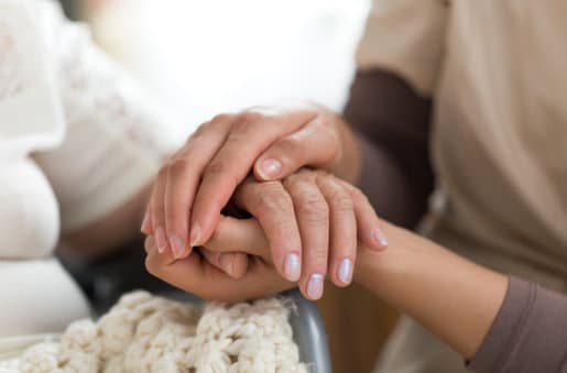 caregiver holding an elderly's hand